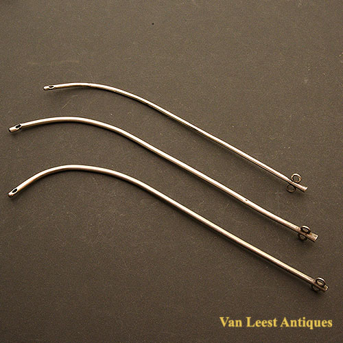 three silver male catheters with solid end.