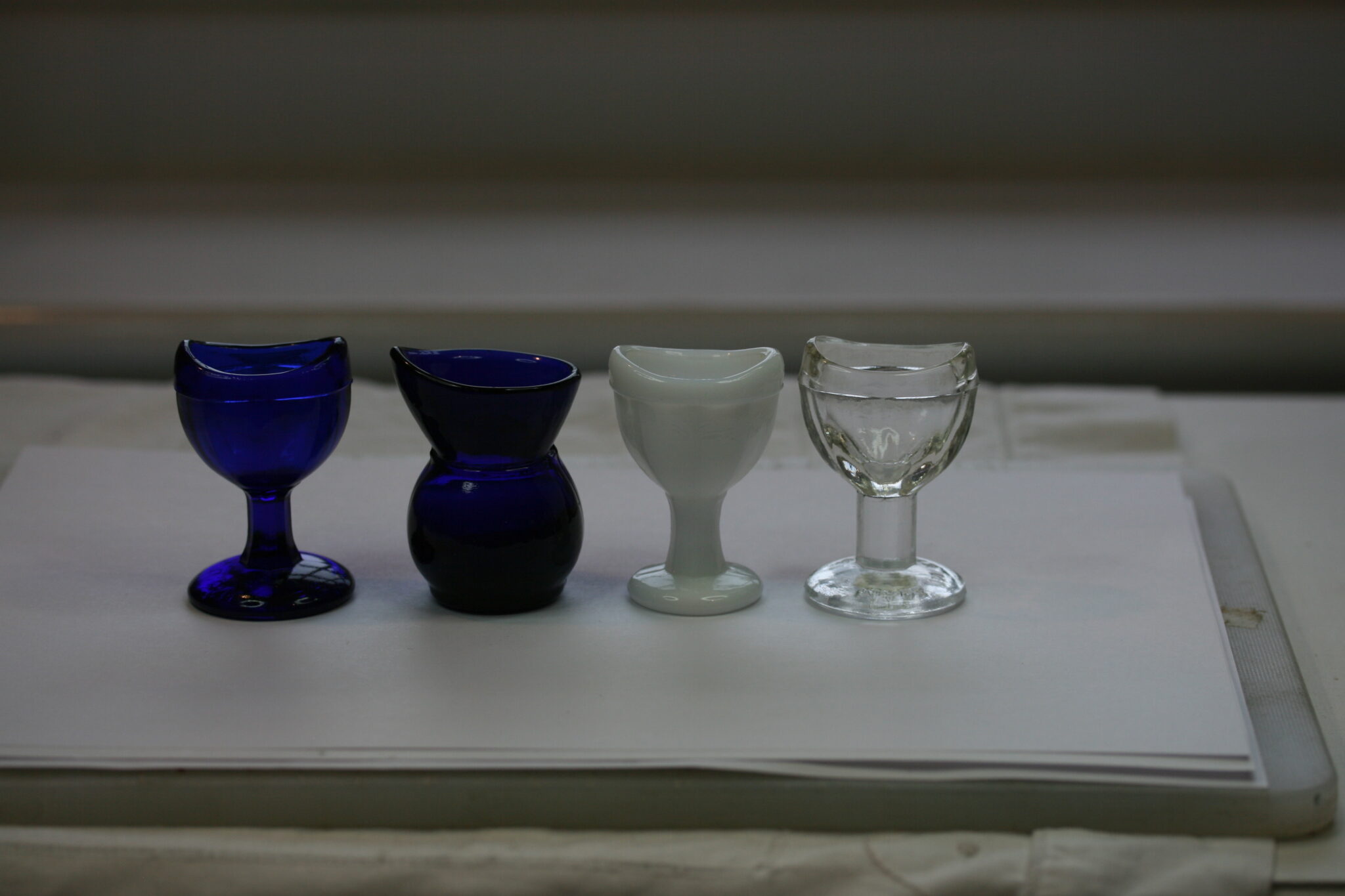 4 x GLASS NAMED EYE BATHS , BLUE ONE WATERSTONE,  WHITE ONE 10-2 ,CLEAR ONE MADE IN ENGLAND M, BLUE ONE BRITISH MADE