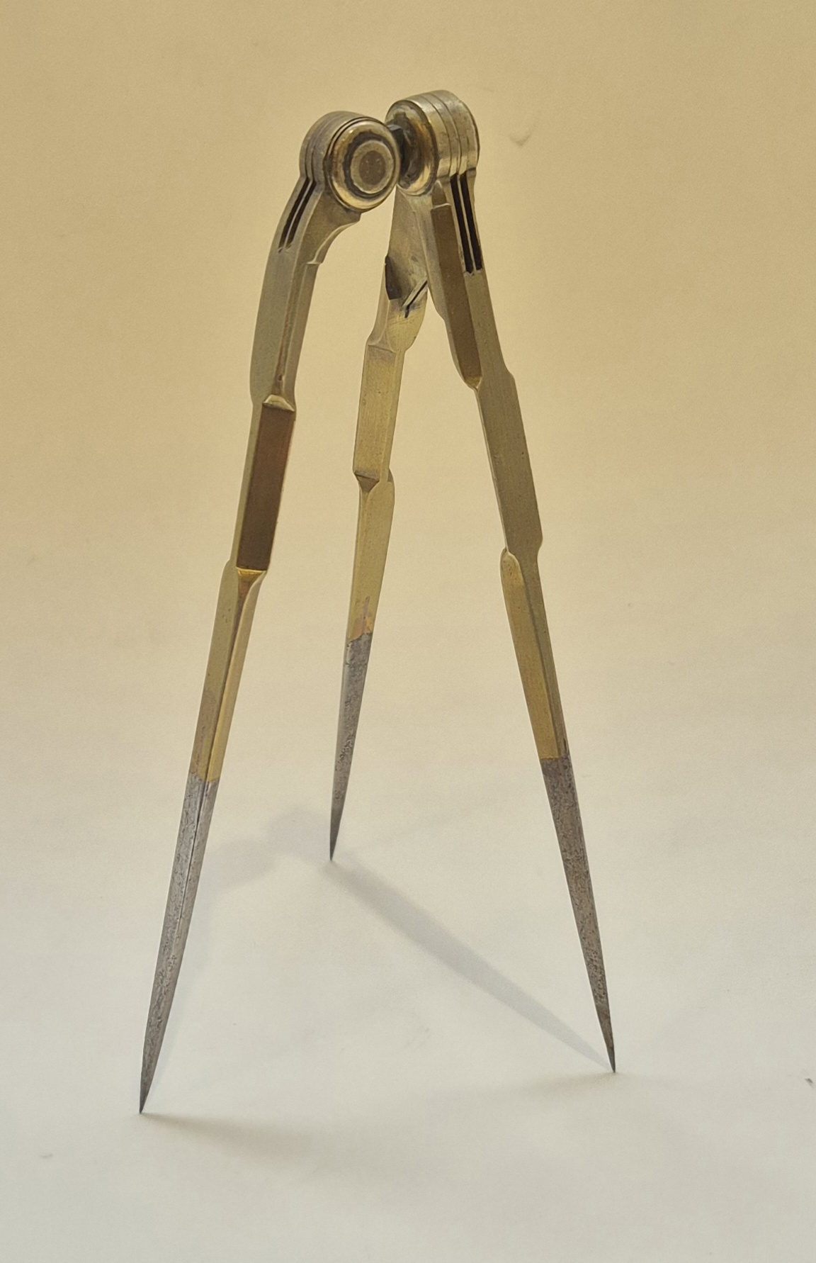 A three-legged French 18th century dividers in brass and steel