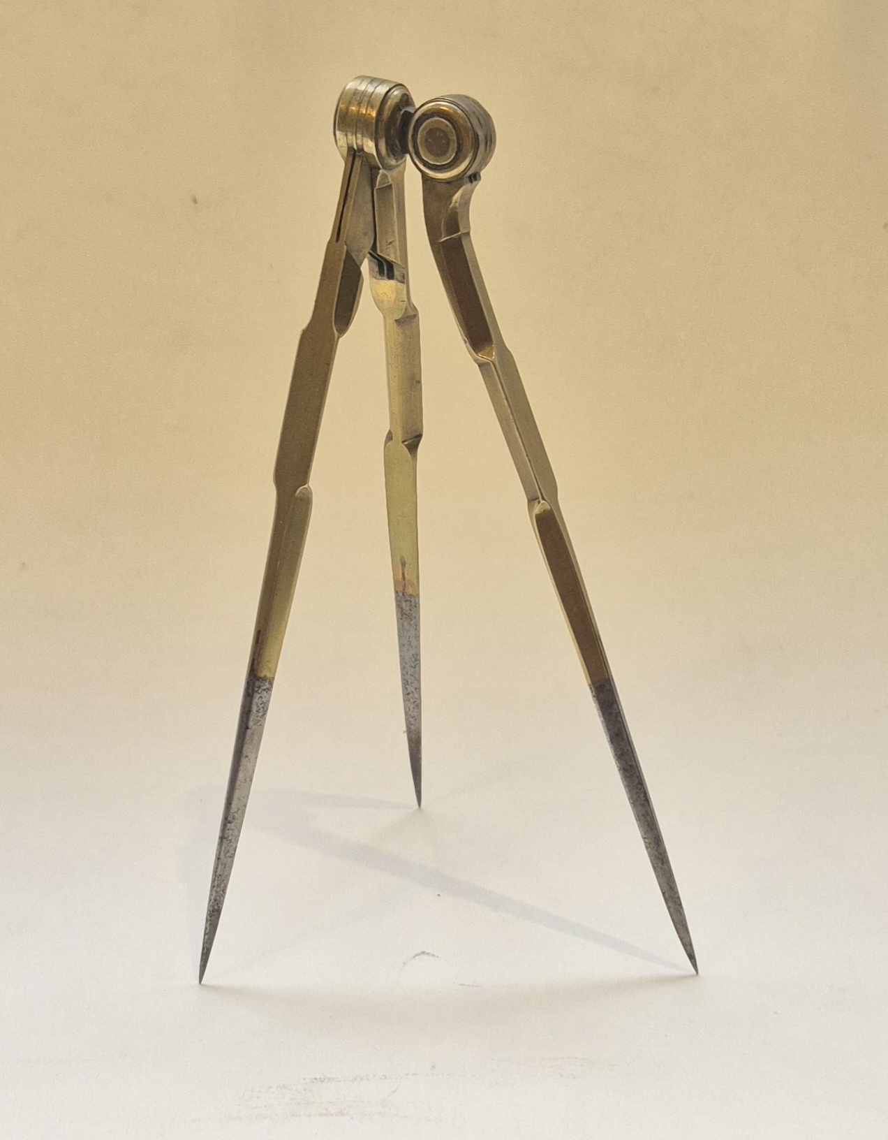 A three-legged French 18th century dividers in brass and steel